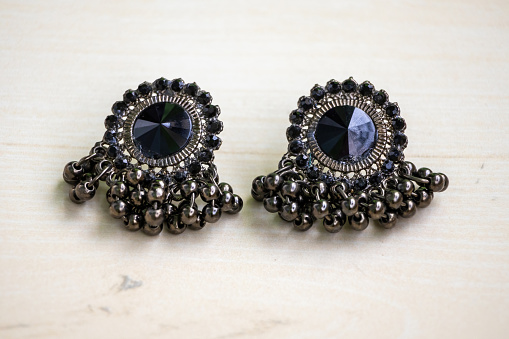 Beautiful antique black earrings on a wooden background. Woman Accessories.