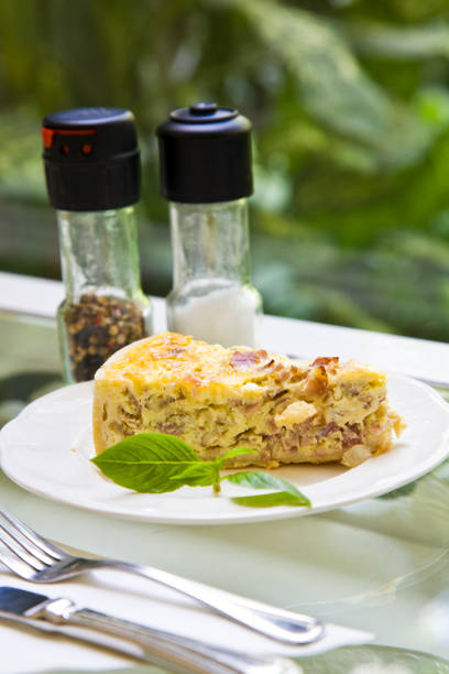 A freshly baked quiche with eggs and meat slices, garnished with herbs, transparent background, concept of delicious food