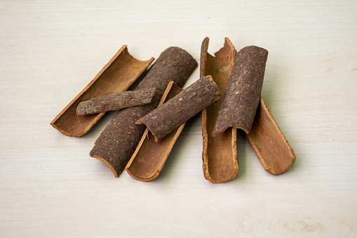Cinnamon sticks (Cinnamomum verum) on a wooden background. Aromatic condiment for cooking.