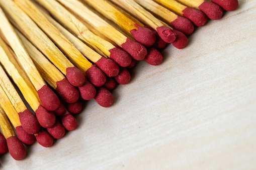 Stack of match sticks on a wooden textured background. Matchsticks are very useful for starting a fire, lighting a candle, burning paper, etc.