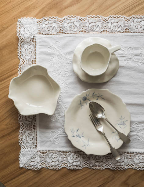 istock Handmade ceramic tableware in retro style - tea pair, bowl, plate, silver cutlery on a wooden table, top view 2148781328