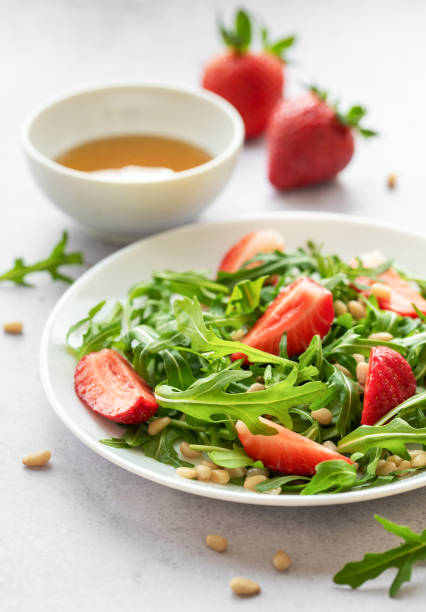 istock Fresh Strawberry Arugula Salad With Pine Nuts Served on a Bright Day 2148782182