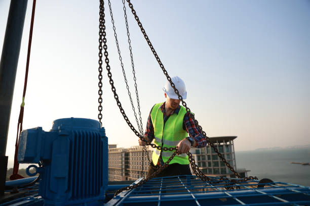 istock An engineer works with a hoist to perform maintenance on the HVAC system and chiller on the rooftop of a building. 2148782384