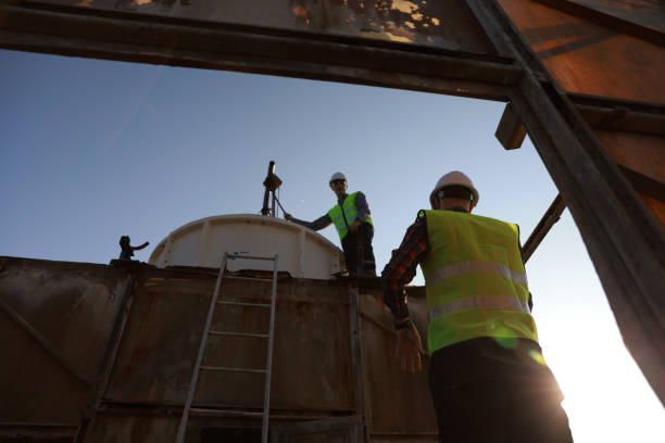 istock Two industrial engineers with safety vests and white hard hat work on the rooftop, HVAC service, industrial, and construction service 2148782402
