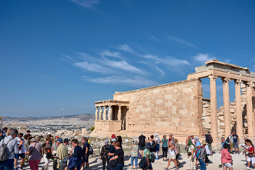 Athens, Greece; October, 13, 2022: View of the Athenian Acropolis from the Caryatid porch of Erechthion against the background of the blue sky and the city of Athens