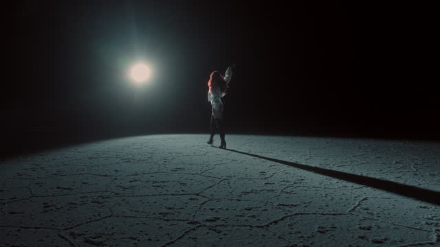 A Redhead Woman in Salt Flat in Bolivia at night under moonlight