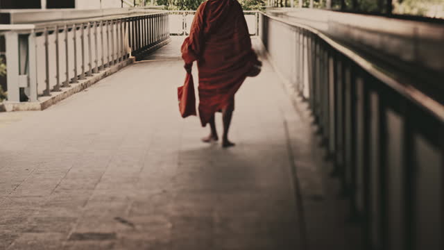 Asian monk walking on the skywalk