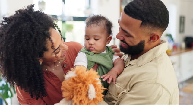 Parents, baby and teddy bear in family home with hug, talking and care with development in childhood. Mother, father and child with toys, playing and bonding for connection with love in apartment