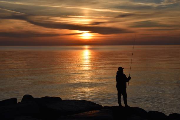 Fisherman at dawn on the rocks