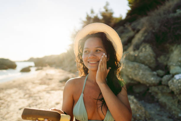 istock Young woman applying sunscreen at the beach 2148787730