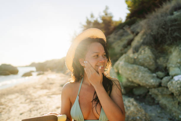 istock Young woman applying sunscreen at the beach 2148787761