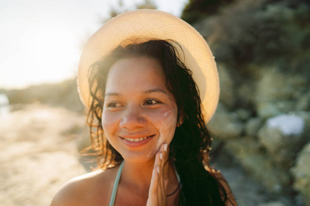 istock Young woman applying sunscreen at the beach 2148787775
