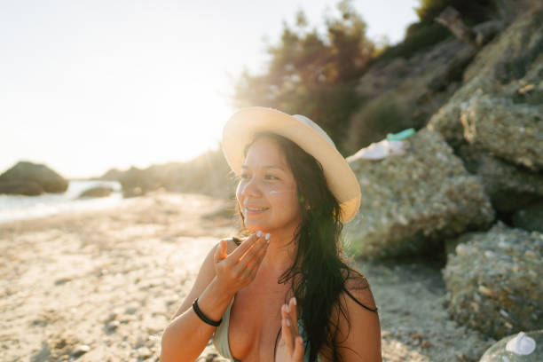 istock Young woman applying sunscreen at the beach 2148787872