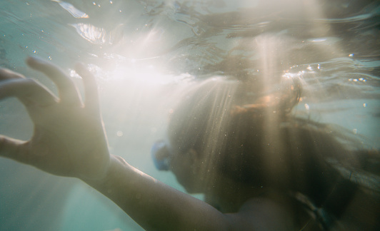 Underwater photo of young Vietnamese woman swimming in the calm sea water
