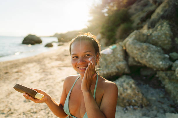 istock Young woman applying sunscreen at the beach 2148789243
