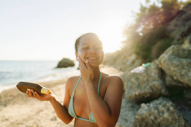 istock Young woman applying sunscreen at the beach 2148789251