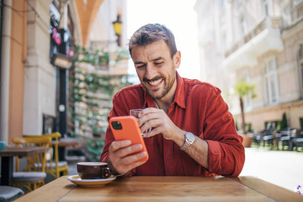 istock Satisfied modern man in stylish casual clothes is using smartphone 2148789370