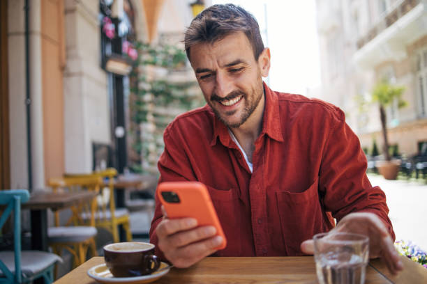 istock Satisfied modern man in stylish casual clothes using smartphone 2148789391