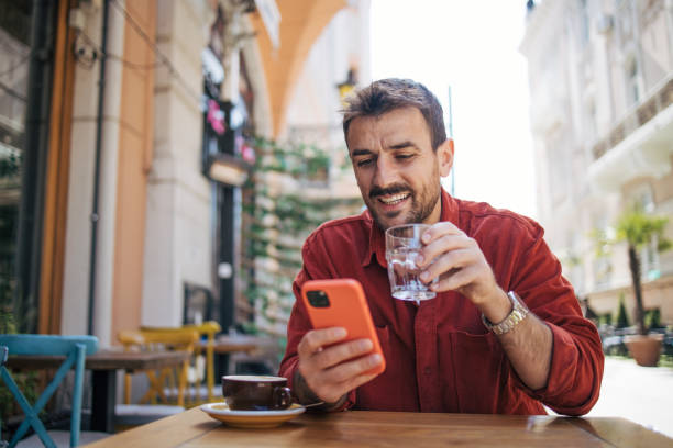 istock Satisfied modern man in stylish casual clothes using smartphone 2148789420