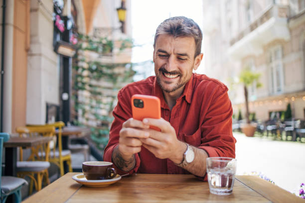 istock Satisfied modern man in stylish casual clothes using smartphone 2148789511