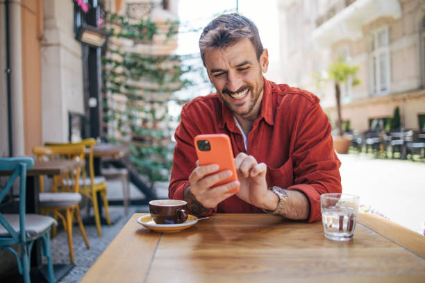istock Satisfied modern man in stylish casual clothes using smartphone 2148789579