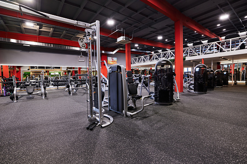 Large group of exercise machines and equipment in a gym.