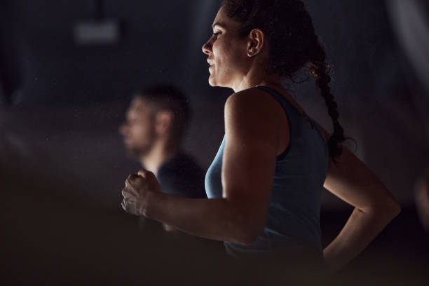 Determined female athlete warming up in a gym.