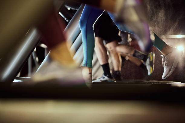 Unrecognizable athletic woman exercising on treadmill in a health club. Copy space.