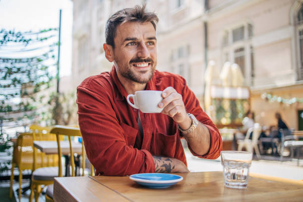 istock Young man sitting in a cafe, having a hot cappuccino 2148789993