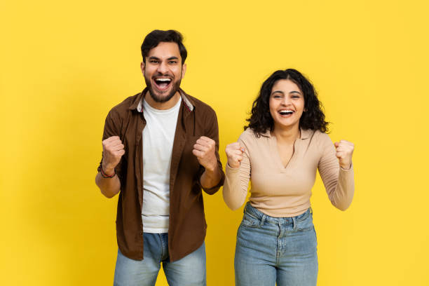 istock Excited Young Couple Celebrating Success On Yellow Background 2148790075
