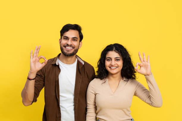 istock Happy Young Couple Making Okay Gesture on Yellow Background 2148790082
