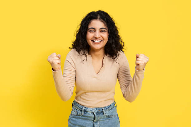 istock Woman Celebrating Success On Yellow Background 2148790083