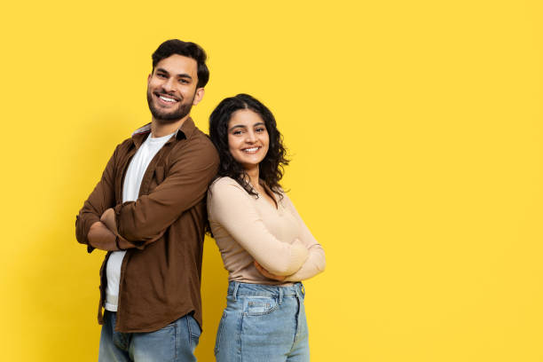 istock Happy Couple Standing Back To Back On Yellow Background 2148790092