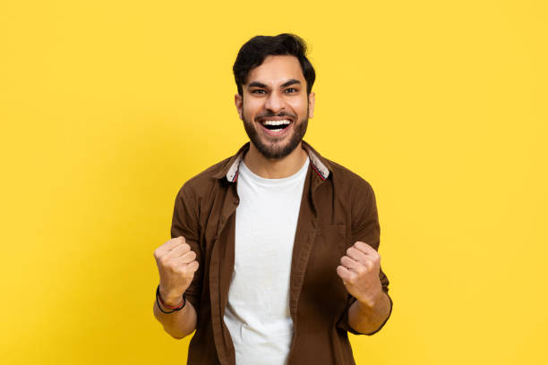 istock Happy Man Celebrating Success On Yellow Background 2148790098