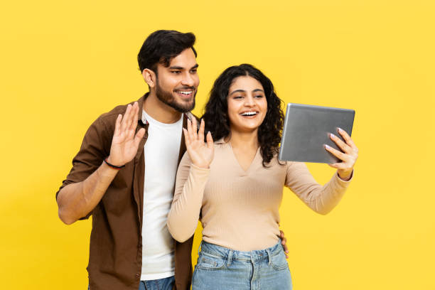 istock Young Couple Smiling And Waving During Video Call On Tablet 2148790166