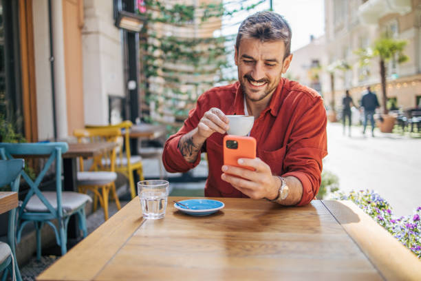 istock Satisfied modern man in stylish casual clothes using smartphone 2148790461