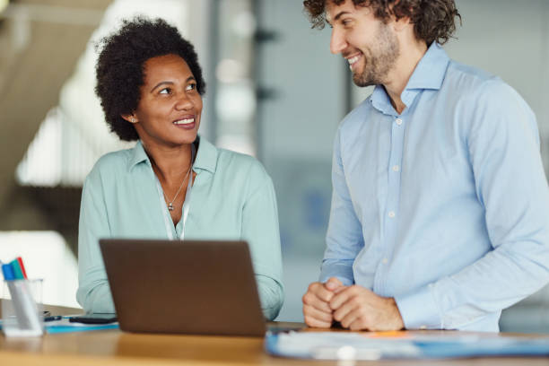 istock Happy business colleagues talking while working on laptop in the office. 2148790462