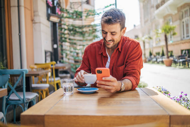 istock Satisfied modern man in stylish casual clothes using smartphone 2148790567