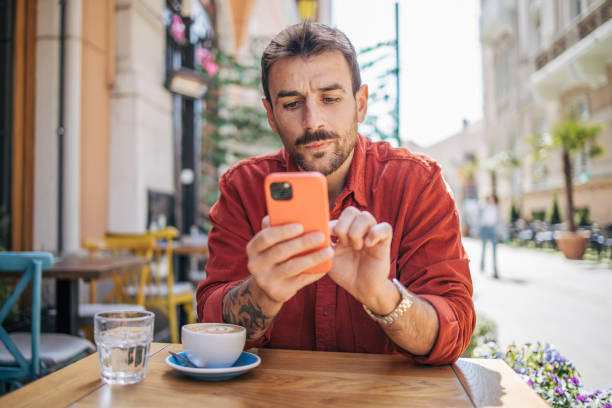 istock Satisfied modern man in stylish casual clothes using smartphone 2148790658