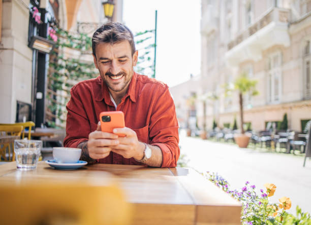 istock Satisfied modern man in stylish casual clothes using smartphone 2148790659