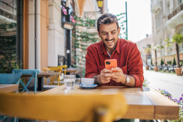 istock Satisfied modern man in stylish casual clothes using smartphone 2148790685