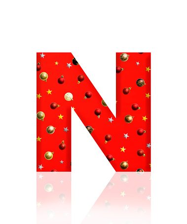 Close-up of three-dimensional Christmas ornament alphabet, red letter N on white background.