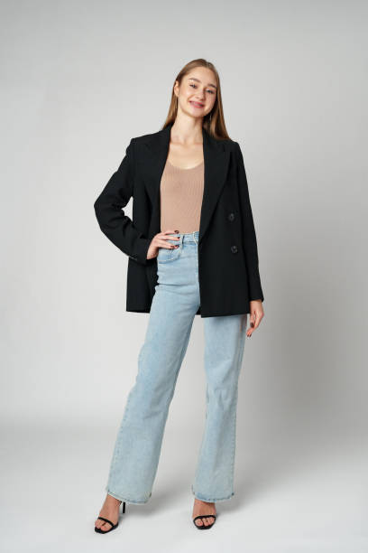 istock Young Woman Wearing Black Jacket and Jeans posing on gray background studio shot . 2148791261