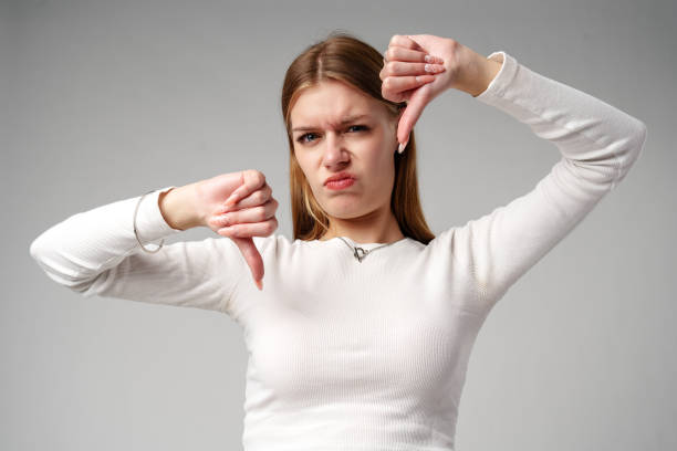 istock Young Woman Pointing Finger Down at Camera in studio 2148791387