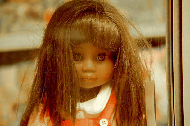 A close up shot of an antique doll's head showing the discolouration and cracks on her face.  But she has such a serene expression.