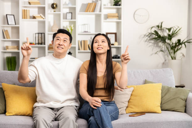 istock Asian Couple Relaxing Together at Modern Home Interior 2148791943