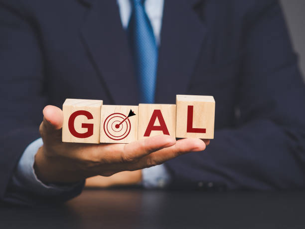 istock Hand holding wooden blocks spelling GOAL with a target symbol. 2148792015