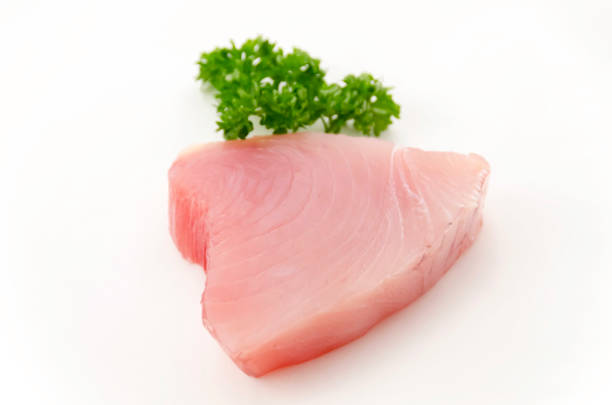Fresh tuna fish fillet steaks with parsley isolated on white background