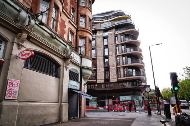 Notting Hill Gate – West London, Kensington And Chelsea, England, United Kingdom, Great Britain, Europe — 06/30/2023: Park Modern: A new luxury development located on Bayswater Road, offering high-end apartments. summer time in the Notting Hill Gate-district.This photograph captures Notting Hill Gate, a renowned landmark in West London. The surrounding architecture reflects the area's rich history, with Victorian-era buildings lining the streets. The photograph provides a glimpse into the cultural melting pot that characterises Notting Hill, a popular destination for tourists and locals alike.–