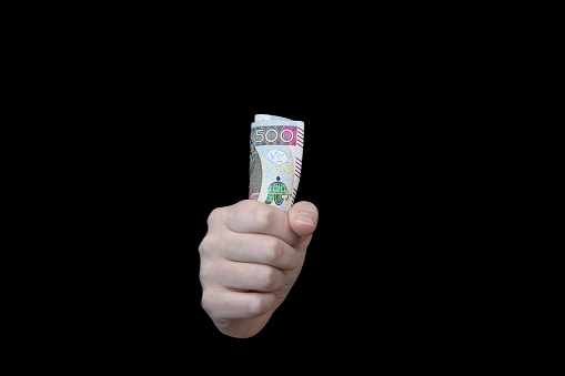Invisible hand of the market, money in hand isolated on black background